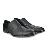 A black vegan leather men's dress shoe with a cap toe. Slightly tapered toe. Lace up with 5 eyelets. Black lining and sole.